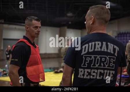 Sgt. 1st Class Ron Poland (left), medical non-commissioned officer, 63rd Civil Support Team, 90th Troop Command, Oklahoma Army National Guard, speaks with a member of the Durant Fire Department during a Regional Emergency Medical Services System training event at the Choctaw Event Center in Durant, Oklahoma, September 21, 2022. (Oklahoma National Guard Photo by Sgt. Reece Heck) Stock Photo