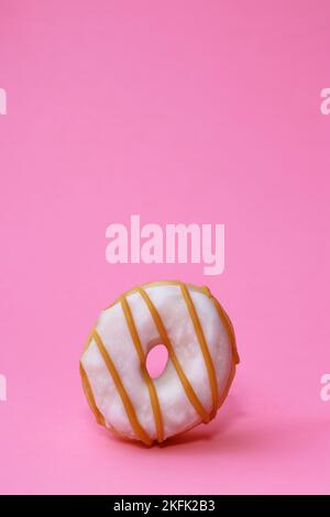 isolated mini donut with white glaze on pink background  Stock Photo