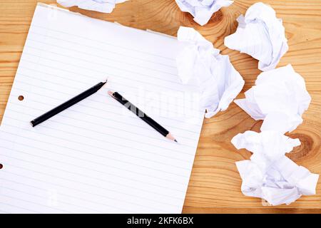 Writers block. a broken pencil and notepad surrounded by crumpled paper. Stock Photo