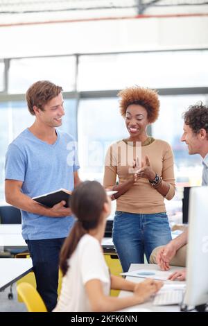 Discussing their latest project. a group of colleagues talking in the office. Stock Photo