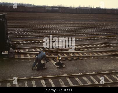 Switchman throwing a switch at C &amp; NW RR's [i.e. Chicago and North Western railroad's] Proviso yard, Chicago, Ill. Stock Photo
