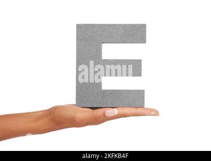 E is for Enterprising. A young woman holding a capital letter E isolated on a white background. Stock Photo