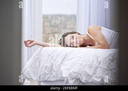 Comfortable on my own bed. a beautiful woman lying on her bed. Stock Photo
