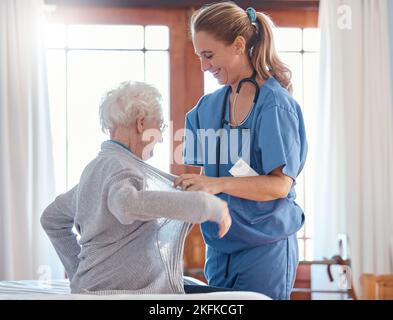 Nurse, healthcare and senior woman in nursing home with physician helping her dress up. Disability, rehabilitation and female medical worker with Stock Photo