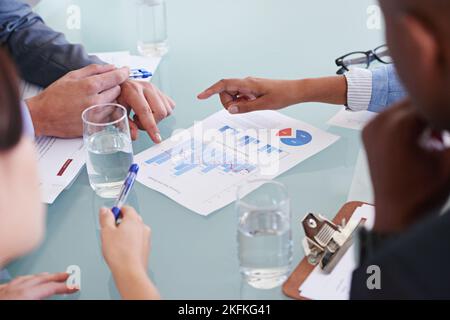 Analyzing the numbers. a group of businesspeople discussing financial documents in a meeting. Stock Photo