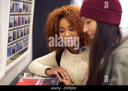 Working together to prepare for finals. two young women studying together in the library. Stock Photo