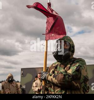 A U.S. Army Soldier with the 153rd Medical Detachment (Blood Support), 56th Multifunctional Medical Battalion, 62nd Medical Brigade, carries the detachment guidon while wearing advanced chemical protective garments on Joint Base Lewis-McChord, Wash., Sept. 23, 2022. Decontamination subject matter experts with the Washington National Guard’s 10th Homeland Response Force taught a 2-day introductory course covering chemical, biological, radiological, and nuclear responder basics, proper wear of protective gear, and hazardous material detection and monitoring. Stock Photo