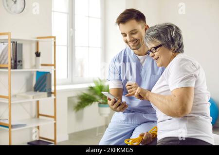 Happy doctor and senior woman using a modern health monitoring app on a mobile phone Stock Photo