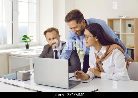 Team of confident business people analyzing data using laptop computer Stock Photo