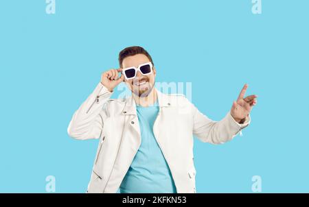 Studio portrait of happy handsome young man in white leather jacket and sunglasses Stock Photo