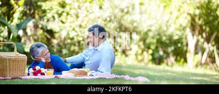 Romance is in the air. a loving senior couple enjoying a picnic together outdoors. Stock Photo