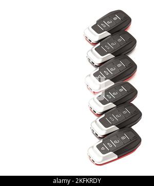 Car keys lie in different poses on a white background. Black and red car alarm key fobs are located on a white background. Stock Photo