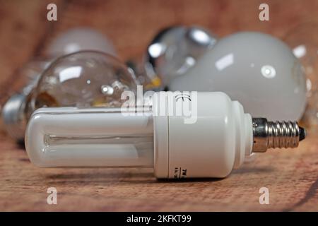 Energy-saving lamp in a close-up in front of incandescent lamps Stock Photo