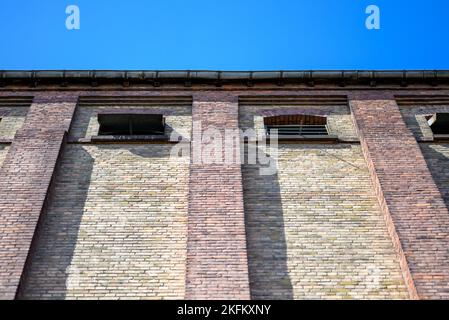 House wall made of different colored bricks in low angel and blue Sky Stock Photo