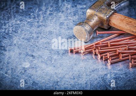Claw hammer brass nails on metallic background. Stock Photo