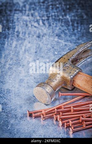 Claw hammer brass construction nails on metallic background. Stock Photo
