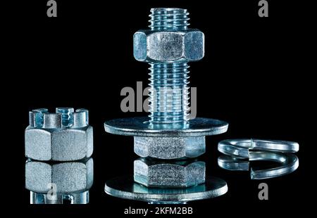 Construction crown nut screwbolt bolt washer on black background. Stock Photo