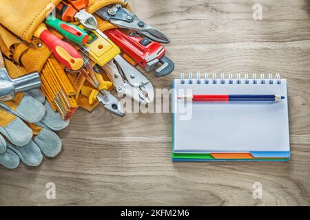Construction tooling tool belt safety gloves claw hammer notebook pencil. Stock Photo
