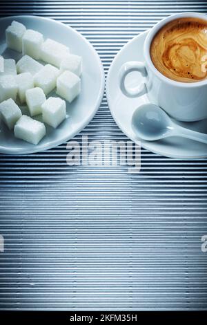 Cup of cappuccino coffee saucer teaspoon sugar cubes on striped background Stock Photo