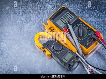 Digital clamp meter electric tester multimeter on metallic background. Stock Photo