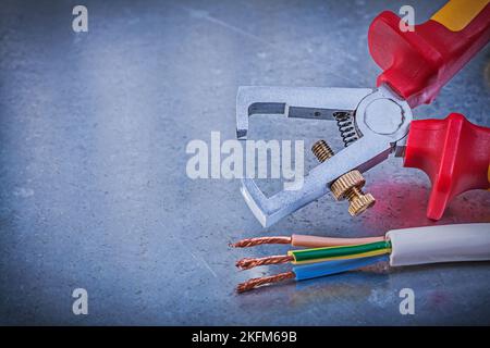 Insulated strippers electric wires on metallic background horizontal version electricity concept. Stock Photo
