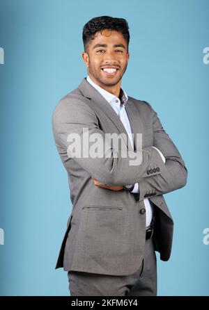 Businessman, happy portrait and pride in suit with arms crossed, motivation and vision for success in mockup studio background. Indian male, corporate Stock Photo