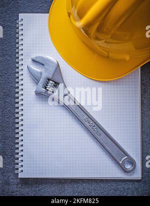 Notebook hard hat adjustable spanner construction concept. Stock Photo