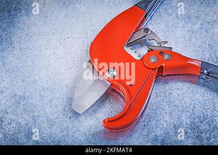 Pipe cutter on scratched metallic background top view construction concept. Stock Photo