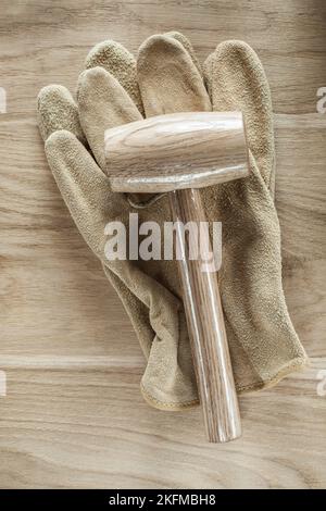 Protective gloves lump hammer on wooden board. Stock Photo