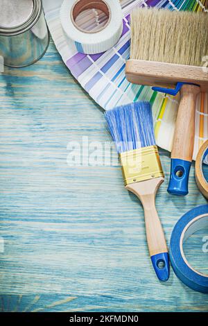 Set of paint cans brushes color sampler adhesive tape on wooden board. Stock Photo