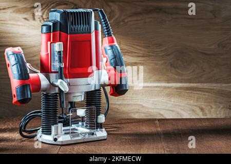 side view red speed variable power small plunge router milling machine portable electric hand mini wood router on wooden background Stock Photo