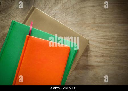 Stack of notebooks on wooden board. Stock Photo