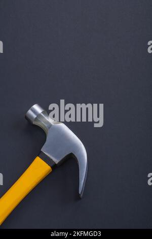 vertical version claw hammer with yellow handle on black background Stock Photo