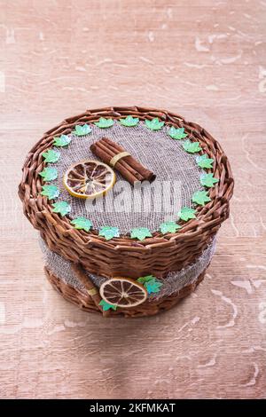 wicker basket without handle on old wooden board Stock Photo