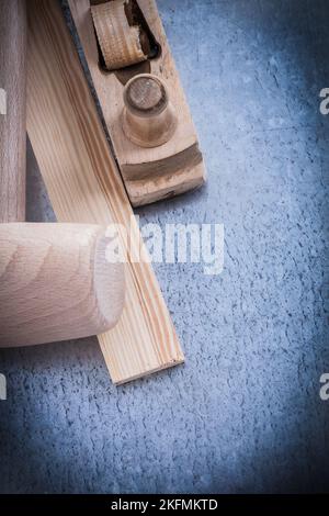 Wooden shaving plane mallet stud on metallic background construction concept. Stock Photo