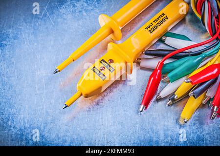 Yellow electrical tester set of multicolored crocodile clip cables on metallic background electricity concept. Stock Photo