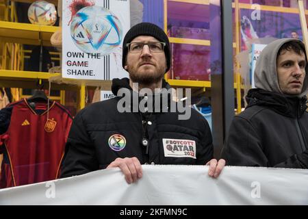 Berlin, Germany. 19th Nov, 2022. Activists gathered in Berlin on November 19, 2022, to draw attention to human rights violations in Qatar. The activists from the group Extinction Rebellion blocked the entrance of the Adidas flagship store on Tauentzienstrasse to protest the sponsorship of the World Cup. A banner reading ''#BoycottQatar2022'' called on the public not to buy any products from the World Cup in Qatar, such as the official Adidas match ball, and not to watch the matches. With the World Cup in Qatar, massive fossil emissions, human rights violations, and the death of guest worker Stock Photo