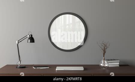 Dark wooden round poster frame mock up on the gray wall of home studio workspace. Front view Stock Photo
