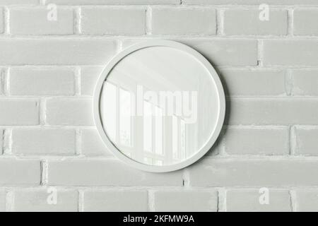 White round frame poster mock up on the white brick wall. Front view Stock Photo
