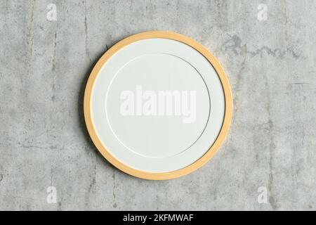 Wooden round frame poster mock up on the concrete wall. Front view Stock Photo