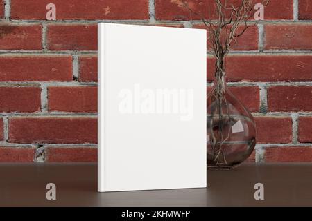 Vertical book cover mock up standing on a dark wooden desk with red brick wall background Stock Photo