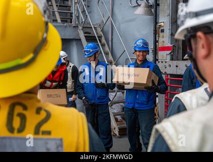 SEA OF JAPAN (Sept. 27, 2022) Sailors aboard Ticonderoga-class guided-missile cruiser USS Chancellorsville (CG 62) receive stores during a replenishment-at-sea with USNS Yukon (T-AO-202) in the Sea of Japan on Sept. 27, 2022. Chancellorsville is forward-deployed to the U.S. 7th Fleet in support of security and stability in the Indo-Pacific and is assigned to Commander, Task Force 70, a combat-ready force that protects and defends the collective maritime interest of its allies and partners in the region. Stock Photo