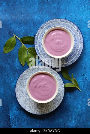 Two blueberry yoghurt bowls on a table. Natural yogurt with organic berries close up photo. Eating fresh concept. Stock Photo
