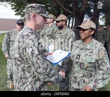 GREAT LAKES, Ill. (September 27, 2022) – Capt. Frank Brown, deputy commander of operations, Naval Service Training Command (NSTC), presents Senior Chief Boatswain’s Mate Fredrika Phillips with an end of tour Navy and Marine Corps Commendation Medal outside the USS North Caroline Transient Barracks on Naval Station Great Lakes here, Sept. 27. The medals were presented to several reserve Sailors who were completing their annual active duty time leading, mentoring and taking care of transient Sailors waiting for their next duty assignment orders. (U. S. Navy photo by Scott A. Thornbloom/Released) Stock Photo