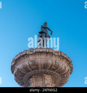 Trento city: Fountain of Neptune isolated on blue background, Cathedral square (Piazza del Duomo) with the bronze statue of the Roman God. Stock Photo
