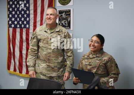 U.S. Army Spc. Jennifer M. Sanchez, Property Book NCO, 92Y, for Headquarters and Headquarters Company, 36th Combat Aviation Brigade, 'Task Force Mustang,' 36th Infantry Division (right), is accompanied by Command Sgt. Maj. Robert W. Hartzog, command sergeant major of Task Force Mustang, while receiving her Certificate of Appreciation as the brigade's 'Hero of the Week' during a command and staff meeting held at Task Force Mustang headquarters, Camp Buehring, Kuwait, Sept. 28, 2022. Sanchez, a native of Nacogdoches, Texas, was recognized for her stellar performance and administrative excellence Stock Photo