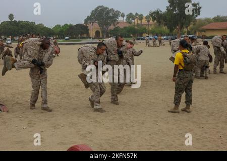 U.S. Marine Corps recruits with Golf Company, 2nd Recruit Training Battalion, execute fireman carries during the combat conditioning course (CCX) at Marine Corps Recruit Depot San Diego, Sept. 28, 2022. The CCX was designed to increase recruits’ stamina and ability to perform Marine Corps Martial Arts Program techniques. Stock Photo