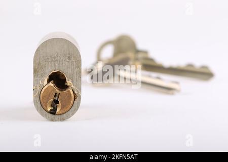 broken lock cylinder with keys on the background Stock Photo