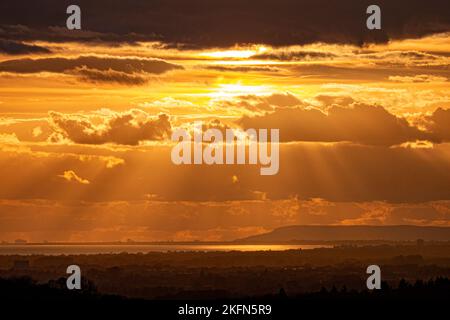 Dramatic sky as the sun sets over the south coast of Sussex and Hampshire with the Isle of Wight silhouetted in the distance. Stock Photo