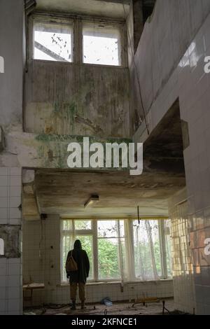 Nuclear apocalypse survivor in abandoned building, stalker life after war, a man traveling on foot in a post-apocalyptic world. Environmental disaster Stock Photo